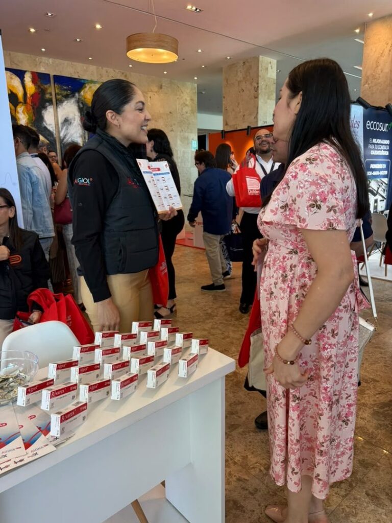 Representante de Dollder conversa con una visitante en el stand del congreso