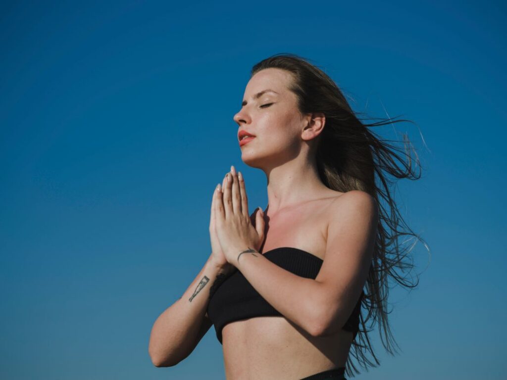 Mujer respirando profundamente con el cielo de fondo