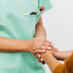 Profesional de salud tomando la mano de un paciente