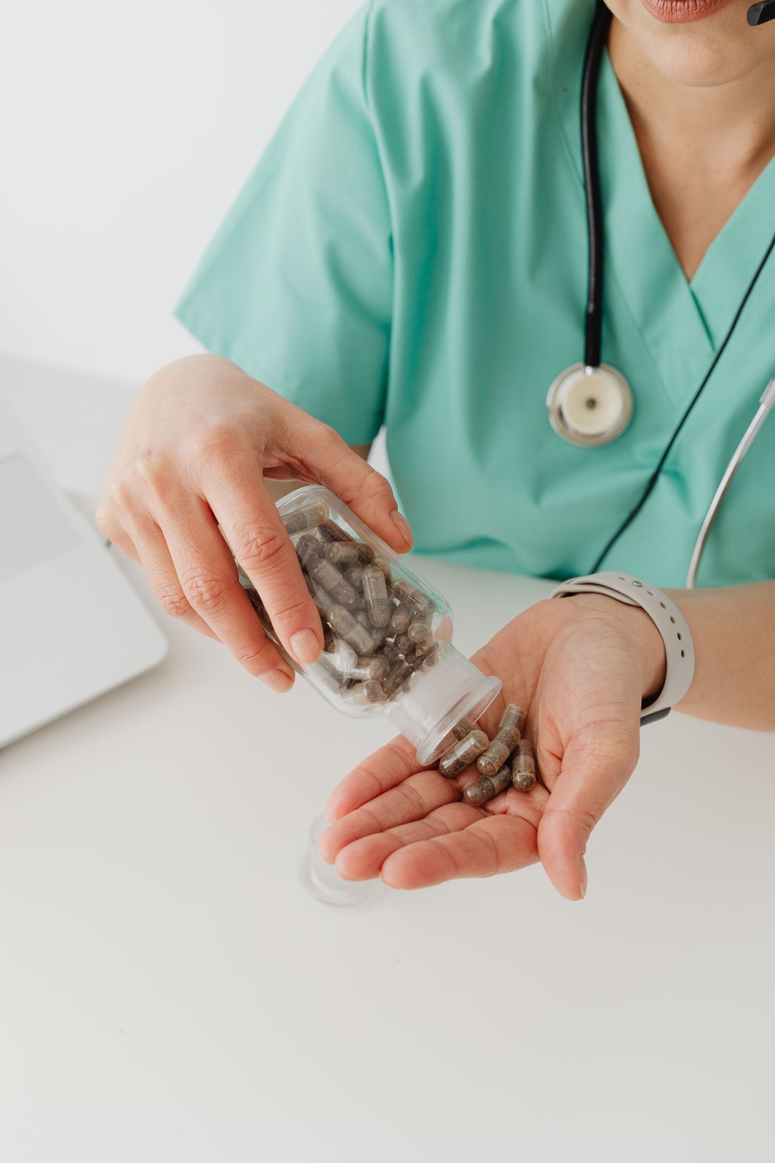 Profesional de salud entregando cápsulas en la mano