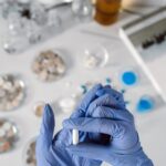 Manos con guantes sosteniendo una cápsula en el laboratorio